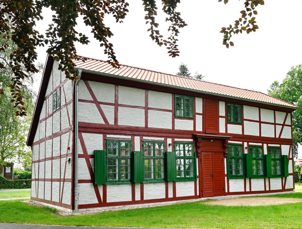 Blick auf ein weiß-rotes Fachwerkhaus mit grünen Fensterläden.
